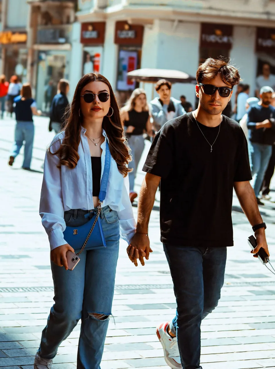 A couple holding hands as they explore a city street
