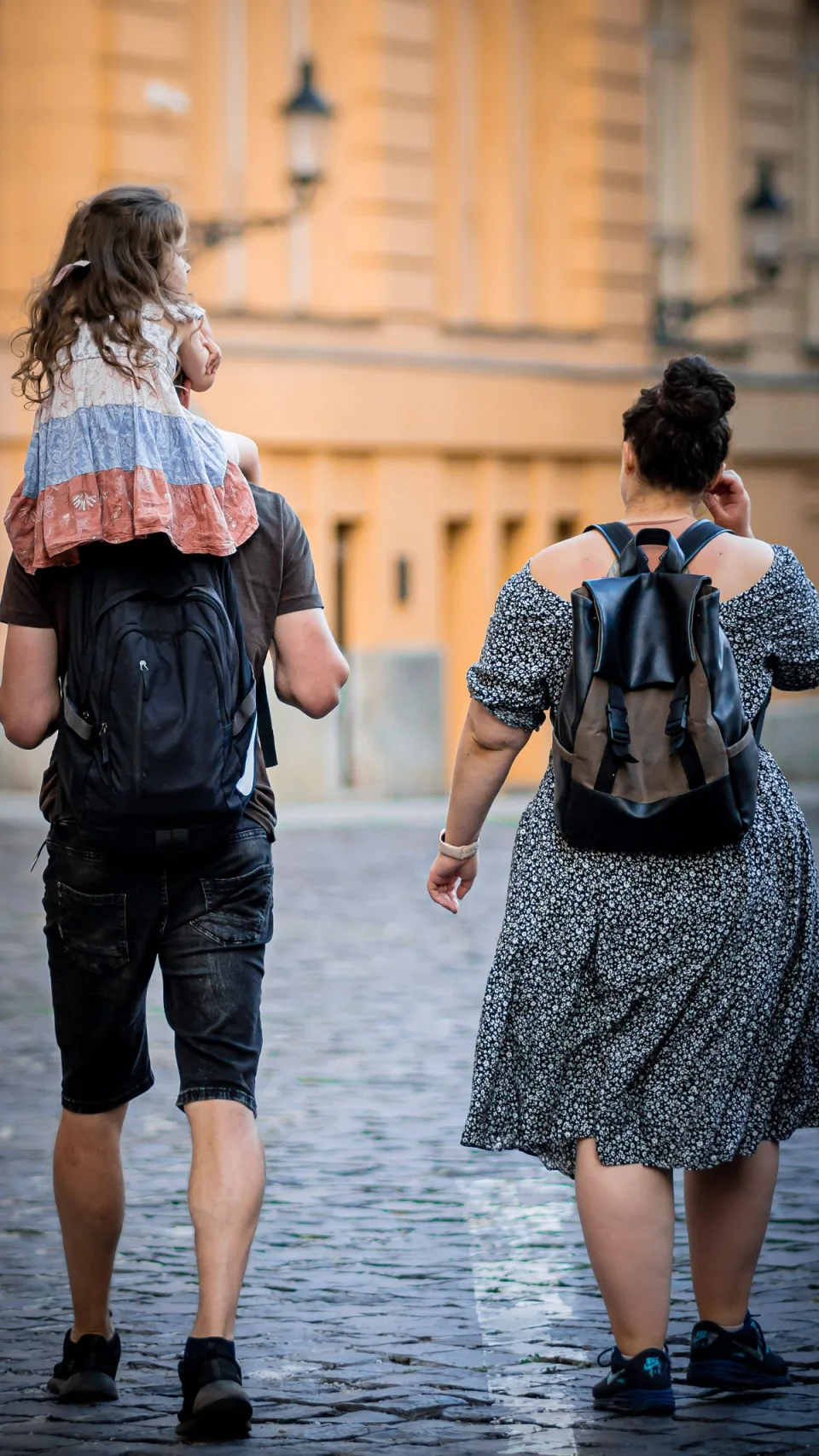 A family exploring together, with a child riding on her dad’s shoulders