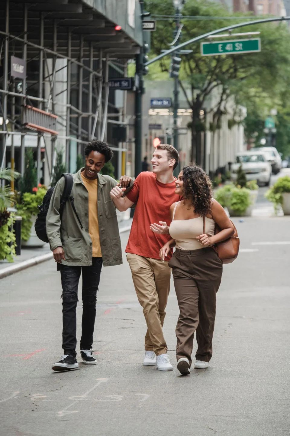 Three friends smiling as they walk together