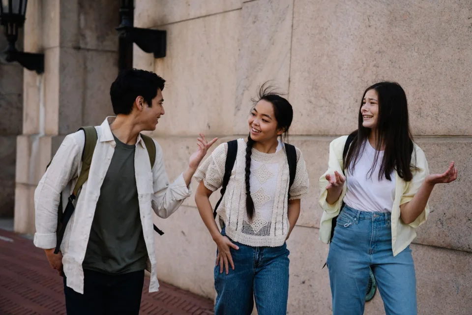 Three friends chatting as they explore a city street